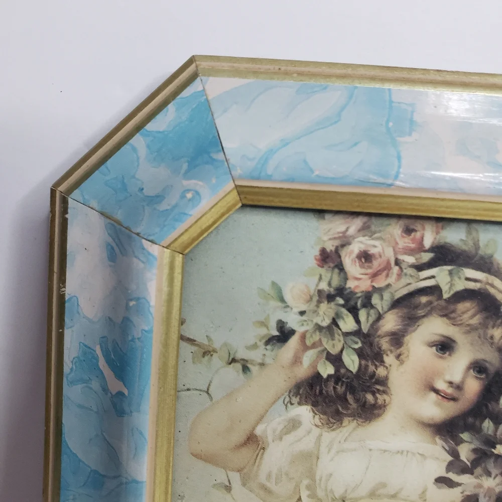 Vintage-style framed print of a young girl adorned with flowers.  228